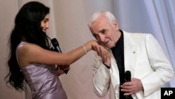Aznavour ki t ap bo men chantèz fransèz Hafsin Herzi anvan levedrido yon seremoni ki ta pral ouvè 62èm Festival Entènasyonal Film Cannes nan, nan pati sid Lafrans, mèkredi 13 me 2009. (Foto: AP/François Mori).