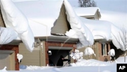 Un Américain cherchant à dégager sa maison à Lancaster, dans l'Etat de New York, le 19 novembre 2014 (AP)