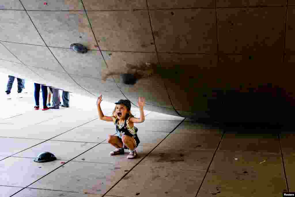 Una niña juega en la escultura Cloud Gate, en Millennium Park, &nbsp;en Chicago.