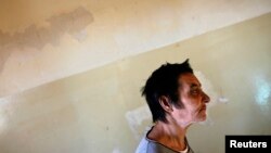 FILE - A patient is seen walking toward a group therapy room at a mental health institution in the Balkans.