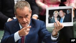 Lãnh đạo đảng đối lập Úc Bill Shorten cầm tấm ảnh chụp giữa Ngoại trưởng Julie Bishop và tỷ phú Trung Quốc Hoàng Hướng Mặc trong khi chất vấn ở Hạ viện tại Canberra ngày 14/6/2017.