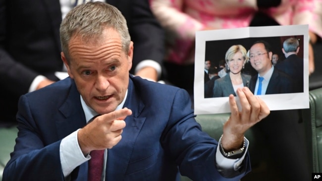 Lãnh đạo đảng đối lập Úc Bill Shorten cầm tấm ảnh chụp giữa Ngoại trưởng Julie Bishop và tỷ phú Trung Quốc Hoàng Hướng Mặc trong khi chất vấn ở Hạ viện tại Canberra ngày 14/6/2017.
