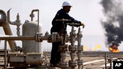 Un trabajador iraquí realiza su tarea en la refinería petrolera de Rumaila, cerca de Basora, 550 kilómetros al sureste de Bagdad, Irak.