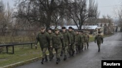 Russian military officers serving at the Joint Center for Control and Coordination (JCCC) march in the town of Soledar, Ukraine, Dec. 17, 2017.