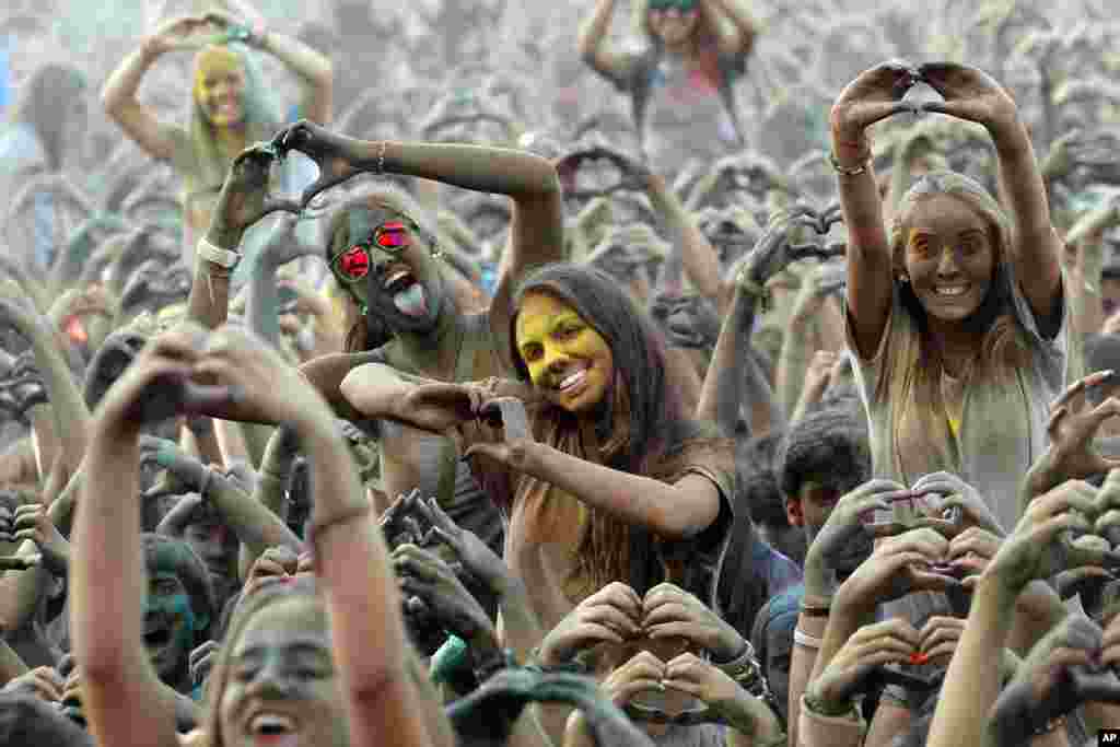 포르투갈 리스본에서 힌두교 성월에서 유래한 &#39;색의 축제&#39;가 열린 가운데, 참석자들이 손으로 하트 모양을 그려보이고 있다.