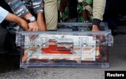 FILE - The flight data recorder from AirAsia QZ8501 is placed into a container upon its arrival at the airbase in Pangkalan Bun, Central Kalimantan, Jan. 12, 2015.