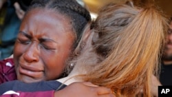 Marla Eveillard, 14, cries as she hugs friends before the start of a vigil at the Parkland Baptist Church, for the victims of Wednesday's shooting at the Marjory Stoneman Douglas High School in Parkland, Fla., Thursday, Feb. 15, 2018. Nikolas Cruz, a former student, was charged with 17 counts of premeditated murder Thursday morning. (AP Photo/Gerald Herbert)