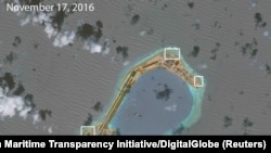 A satellite image shows what CSIS Asia Maritime Transparency Initiative says appears to be anti-aircraft guns and what are likely to be close-in weapons systems (CIWS) on the artificial island Subi Reef in the South China Sea in this image released on Dec