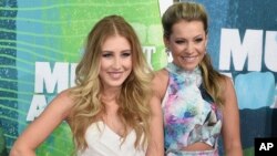 FILE - Tae Dye, right, and Maddie Marlow, of the musical group Maddie & Tae, arrive at the CMT Music Awards in Nashville, Tennessee, June 10, 2015. 