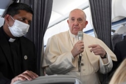 Paus Fransiskus menyapa para jurnalis di atas pesawat kepausan pada kesempatan kunjungan pastoralnya ke Siprus dan Yunani, 6 Desember 2021. (Alessandro Di Meo/Pool via AP)