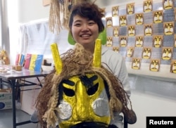 Kokoro Ohtani, 24, an employee of Oga City Hall, holds a Namahage mask as she poses for a photogarph during an interview with Reuters in Oga, Japan, Feb. 8, 2019.
