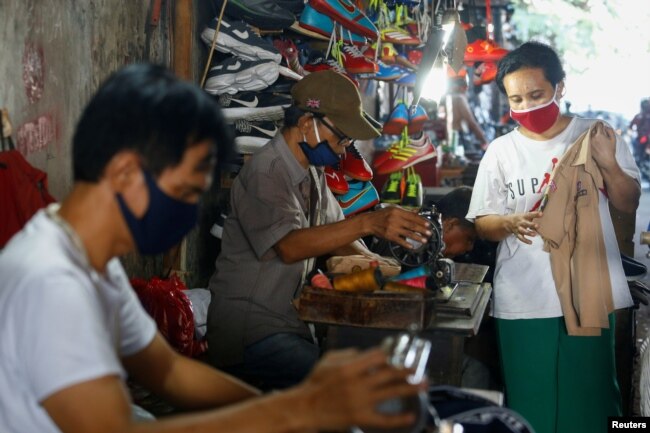Para penjahit di bawah jembatan Jatinegara mengenakan masker pelindung di tengah pandemi virus corona (Covid-19) di Jakarta, 22 Juli 2020 (Foto: Reuters)