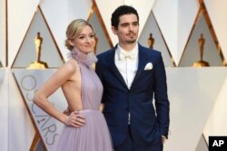 Olivia Hamilton, left, and Damien Chazelle arrive at the Oscars on Sunday, Feb. 26, 2017, at the Dolby Theatre in Los Angeles.