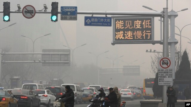 Una señal de tránsito en Beijing dice "Baja visilidad, reduzca la velocidad" en un día de alta contaminación, el lunes, 30 de noviembre de 2015.

