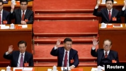 中共总书记习近平和前总书记江泽民、胡锦涛等人举手表决（2017年10月24日）。
