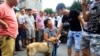An animal activist kneels down as she offers to buy a dog from a vendor, second right, to stop it from being eaten ahead of the annual dog meat festival in Yulin, Guangxi Zhuang Autonomous Region, June 20, 2014. 