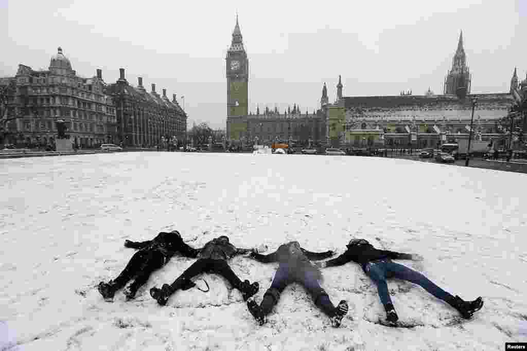 1月18日。英國倫敦罕見大雪後﹐青年躺雪地﹐擺白雪天使姿勢。(路透社)