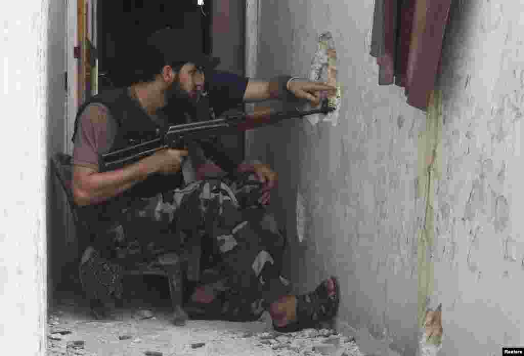 Free Syrian Army fighters take their positions as they try to locate snipers loyal to Syria's President Bashar al-Assad in Bab al-Nasr district in the old city of Aleppo, August 20, 2013.