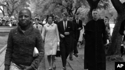 FILE - In this June 5, 1966, file photo Sen. Robert F. Kennedy, back right, and his wife, Ethel, back left, arrive at the Roman Catholic Cathedral in Pretoria, South Africa, during a visit to the country.