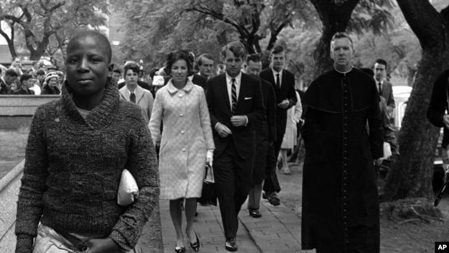 FILE - In this June 5, 1966, file photo Sen. Robert F. Kennedy, back right, and his wife, Ethel, back left, arrive at the Roman Catholic Cathedral in Pretoria, South Africa, during a visit to the country.