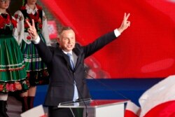 President Andrzej Duda flashes victory signs after voting ended in the presidential election in Lowicz, Poland, Sunday, June 28, 2020.