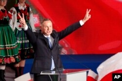 President Andrzej Duda flashes victory signs after voting ended in the presidential election in Lowicz, Poland, Sunday, June 28, 2020.