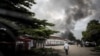 Un homme se dirige vers la fumée d'un incendie dans l'entrepôt de la Commission électorale nationale indépendante (CENI) le 13 décembre 2018 à Kinshasa.