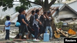 Warga mengevakuasi jenazah korban gempa bumi dan tsunami di Palu, Sulawesi Tengah, 29 September 2018. (Foto: Antara via Reuters)