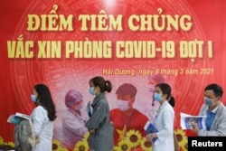 FILE PHOTO: Health workers wait for their turn as Vietnam starts its official rollout of AstraZeneca's coronavirus disease (COVID-19) vaccine for health workers, at Hai Duong Hospital for Tropical Diseases, Hai Duong province, Vietnam, March 8, 2021.