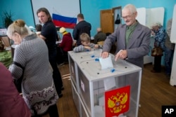 FILE - A Russian casts his ballot at a polling station in Kostroma, Sept. 13, 2015. A recent Levada Center poll showed declining support for the ruling party as the Sept. 18 parliamentary elections approach..