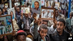 Members of Ethiopia's Jewish community hold pictures of their relatives in Israel, during a solidarity event at the synagogue in Addis Ababa, Ethiopia, Feb. 28, 2018.