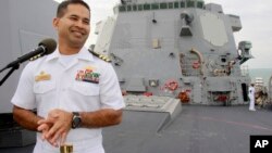 In this photo taken Dec. 3, 2010, U.S. navy officer Michael "Vannak Khem" Misiewicz smiles as he delivers his welcome speech on the deck of the U.S. Navy destroyer USS Mustin at Cambodian coastal international see port of Sihanoukville, about 220 kilometers (137 miles) southwest of Phnom Penh, Cambodia.