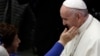 FILE - A woman reaches to touch Pope Francis during an audience at the Vatican, Nov. 30, 2018.