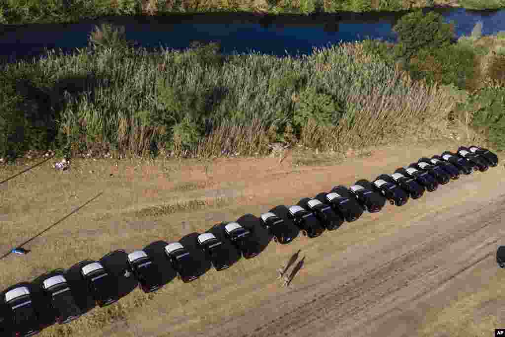 Texas Department of Safety vehicles lines the bank of the Rio Grande near an encampment of migrants, many from Haiti, in Del Rio, Texas.