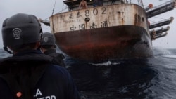 In this July 2021 photo provided by Sea Shepherd, crew members of the Ocean Warrior approach a Chinese-flagged vessel whose Indonesian crew said they had been stuck at sea for years.