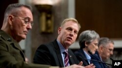FILE - Acting Defense Secretary Patrick Shanahan, center, accompanied by Joint Chiefs Chairman Gen. Joseph Dunford, left, and Secretary of the Air Force Heather Wilson, speaks during a Senate Armed Services Committee hearing on Capitol Hill in Washington.