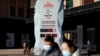 Pedestrians walk past a countdown clock for the Beijing 2022 Winter Olympic Games in Beijing, China, Dec. 7, 2021.