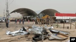 Para petugas keamanan memeriksa lokasi bom bunuh diri di kota Suwayrah, 40 kilometer selatan kota Baghdad, Irak (21/4).
