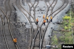 FILE - Workers inspect railway tracks for the Belt and Road freight rail route linking Chongqing, China, with Duisburg, Germany, at the Dazhou railway station in Sichuan province, China March 14, 2019.