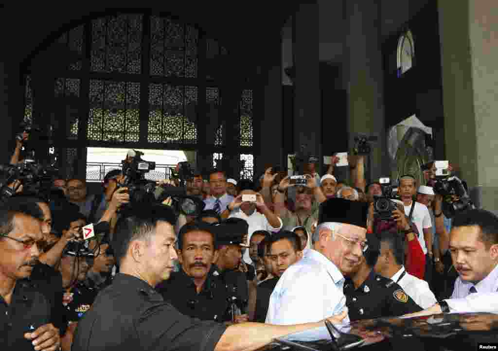 Malaysia's Prime Minister Najib Razak leaves after Friday prayers that included special prayers for passengers of flight MH370 at a mosque near Kuala Lumpur International Airport, March 14, 2014. 