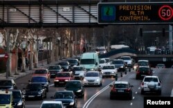 FILE - A sign warns drivers of "High levels of pollution expected" in Madrid, Feb. 8, 2011.