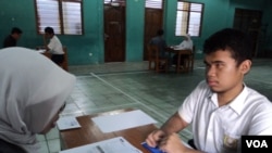 Agung Pamuji, salah seorang siswa tunanetra saat mengikuti Ujian Nasional SMP di Solo, Senin, 5 Mei 2014 (VOA/Yudha).