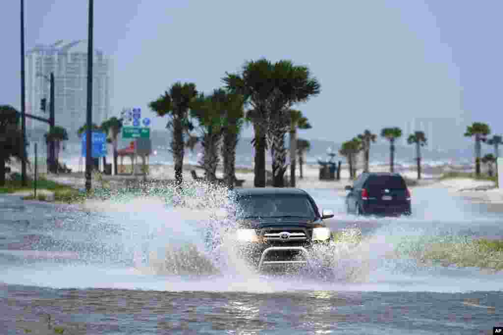 Cars drive through flood waters along route 90 as outer bands of Hurricane Ida arrive in Gulfport, Mississippi.