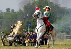 FILE - An actor posing as Russian Czar Peter the Great, right, takes part in a staged battle re-enactment to mark the 300th anniversary of the Battle of Poltava in Moscow, Russia, July 9, 2009.