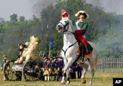 FILE - An actor posing as Russian Tsar Peter the Great, on the right, takes part in a staged battle rehearsal to mark the 300th anniversary of the Battle of Poltava in Moscow, Russia, on July 9, 2009.