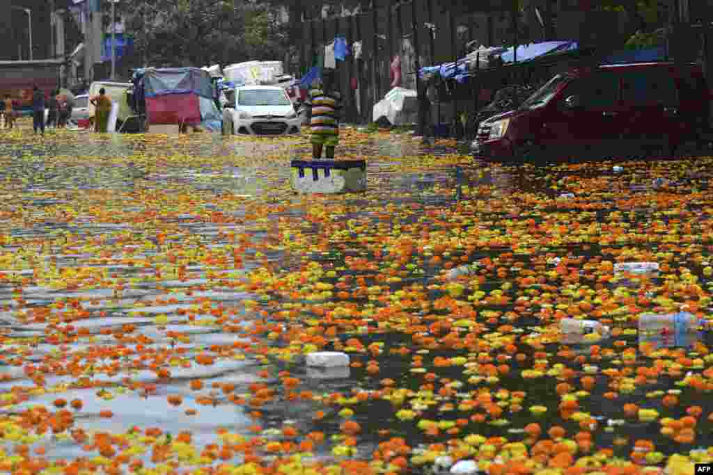 A seller stands in a flooded flower market following heavy monsoon rains in Mumbai, India.