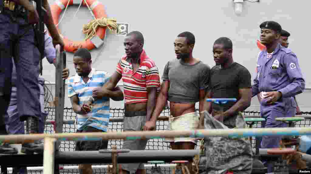 Suspected pirates are escorted aboard a naval ship after their arrest by the Nigerian Navy at a defence jetty in Lagos, August 20, 2013.