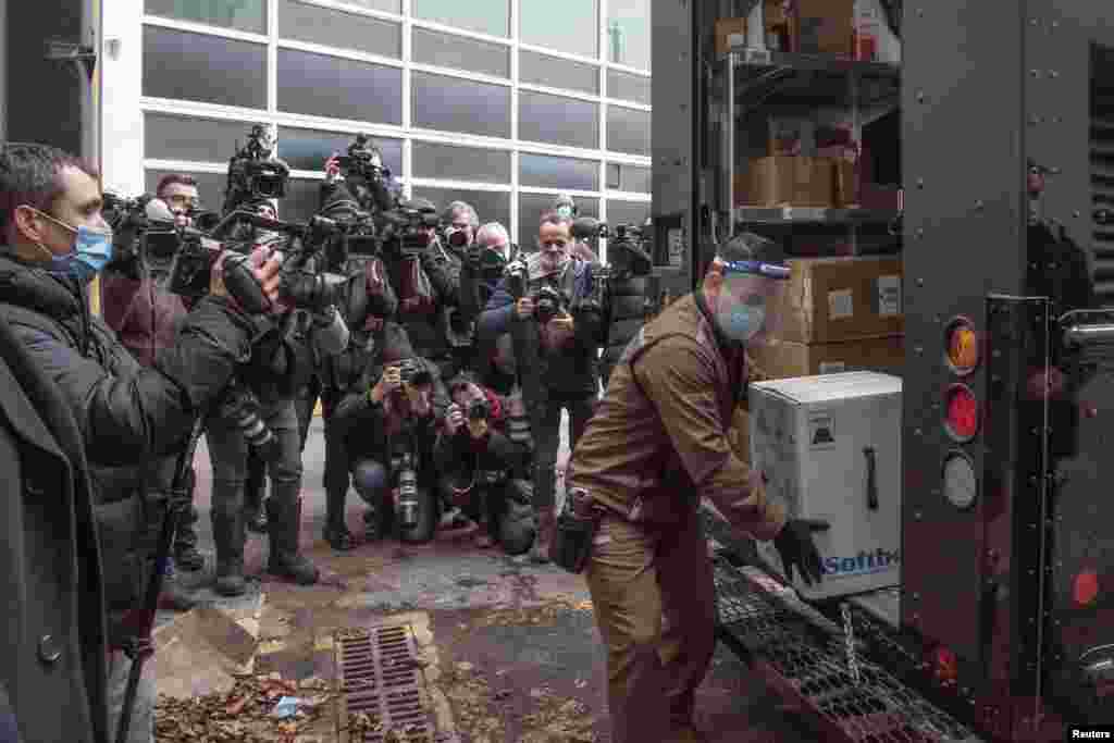 A box of Pfizer/BioNTEch COVID-19 vaccine is delivered from a UPS truck past news photographers to the Maimonides long term care home in Montreal, Quebec, Canada, Dec. 14, 2020. (Quebec Ministry of Health and Social Services/Handout)