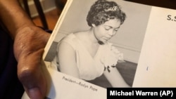 In this March 4, 2020 photo, Roslyn Pope shows her Spelman College yearbook at her home in Atlanta. As a 21-year-old Spelman senior in March 1960, Pope wrote "An Appeal for Human Rights." (AP Photo/Michael Warren)