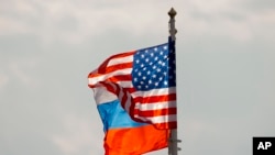 U.S. and Russian national flags wave in the wind before U.S. Secretary of State Rex Tillerson arrival at Moscow's Vnukovo airport, April 11, 2017. 